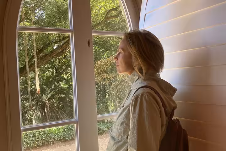 Woman gazing out a window at lush greenery during a Lisbon to Sintra guided tour, capturing a moment of reflection.