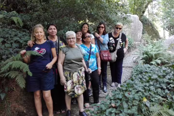 Group of tourists exploring lush greenery on a private 2-day tour in Lisbon, Sintra, Roca, and Cascais.