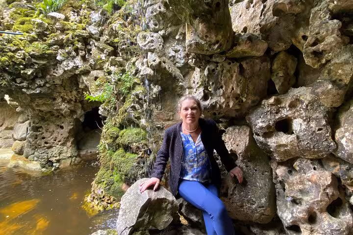 Visitor exploring lush grotto at Regaleira Estate on Lisbon to Sintra guided tour.
