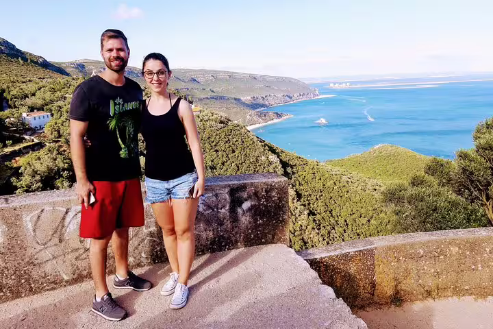 Couple enjoying scenic views of Arrábida Natural Park and coastline on Lisbon's South Sights & Wine tour.