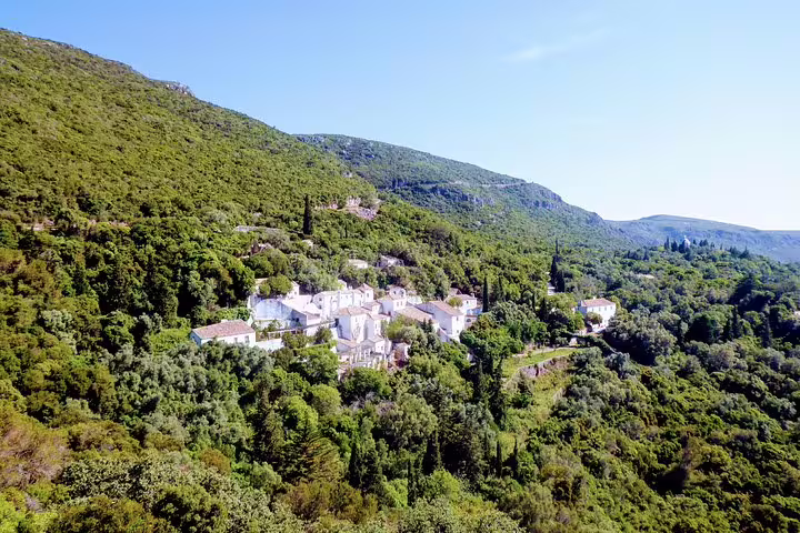 Scenic aerial view of lush green hills and a charming village in Lisbon's south, ideal for wine tours and sightseeing adventures.