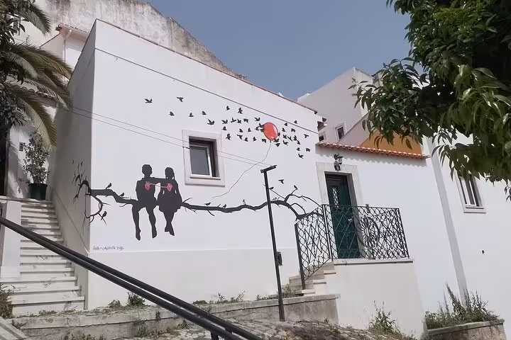 Discover Lisbon's vibrant street art featuring silhouettes and birds on a historical walking tour.