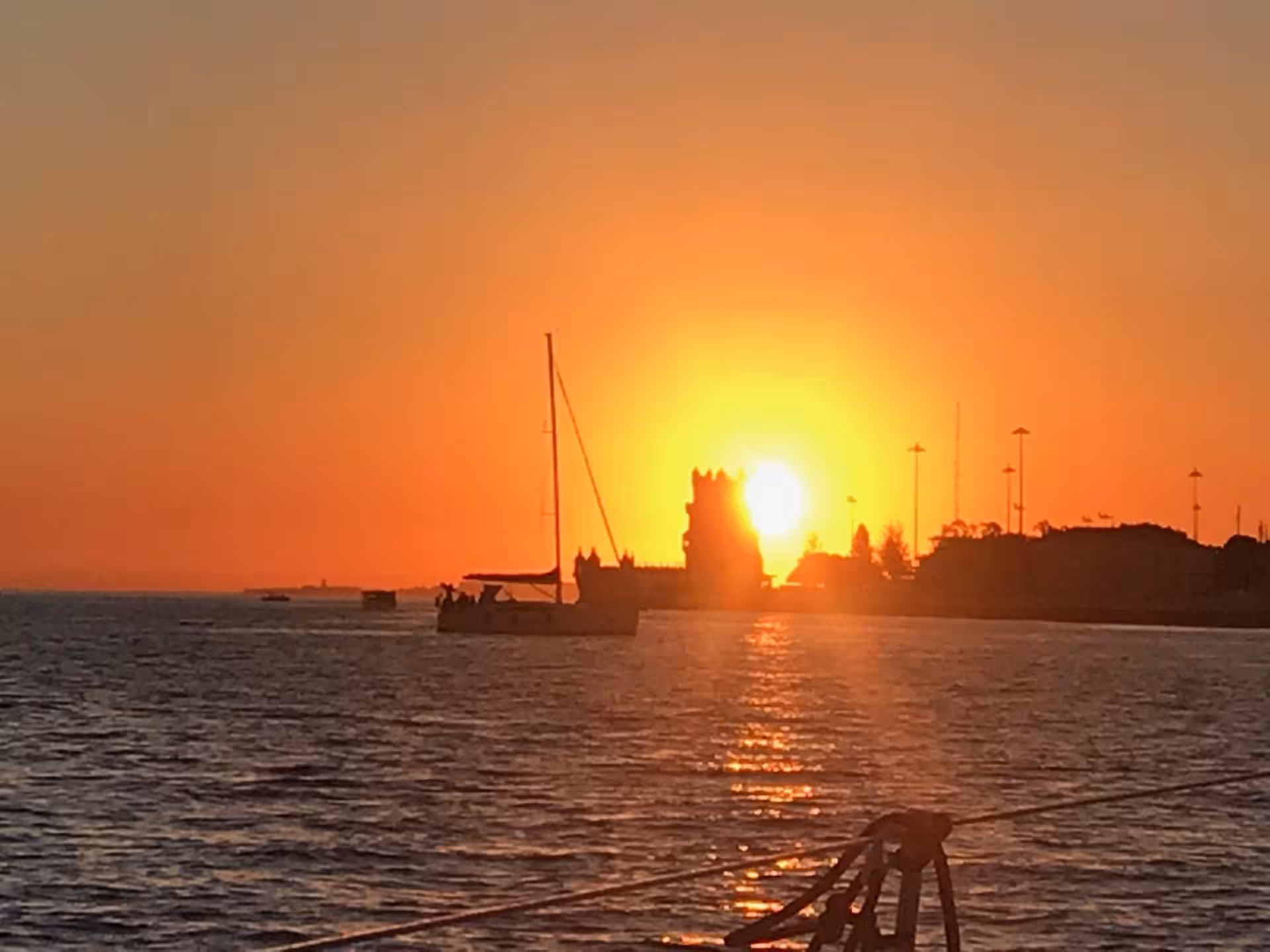 Lisbon sunset boat tour on the Tagus River with sailboat near Belém Tower, golden views and wine tasting