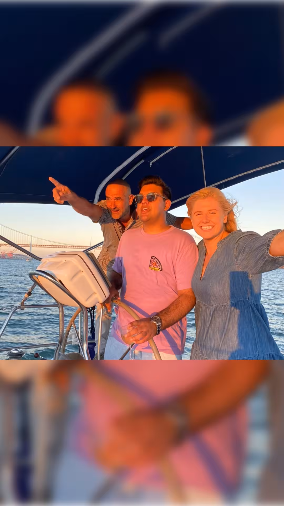 Friends on a Lisbon sunset boat tour on the Tagus River, enjoying a welcome drink near 25 de Abril Bridge