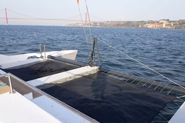View from the catamaran on the Tagus River with Lisbon's iconic 25 de Abril Bridge in the background.