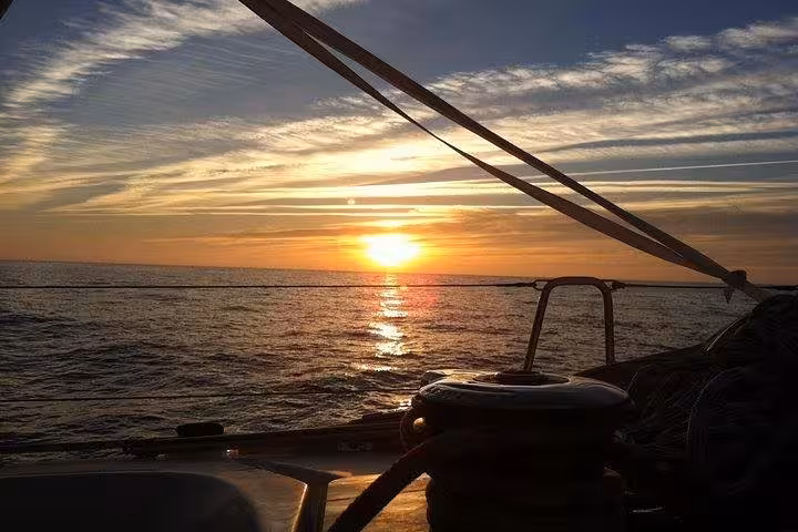 Sunset view from sailboat deck on Lisbon small-group sailing cruise, Atlantic horizon and golden light