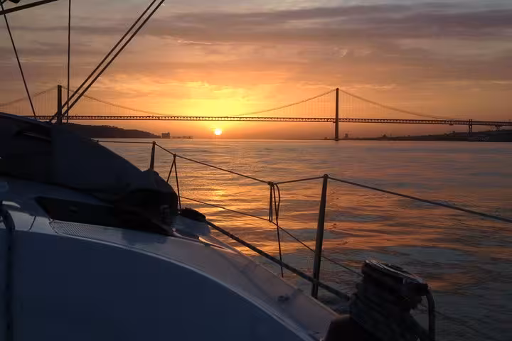 Lisbon sunset sailing cruise view from yacht deck on Tagus River, 25 de Abril Bridge, 2h tour with drink