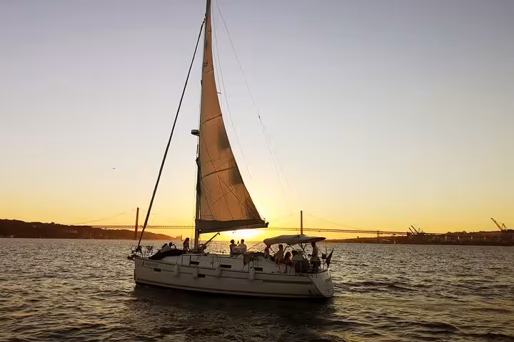 Sailboat on Lisbon Tagus River at sunset near 25 de Abril Bridge, 2-hour small group cruise with drink