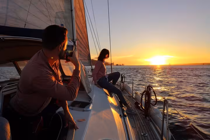 Couple relaxing on a luxury sailing yacht at sunset in Lisbon, Tagus River cruise with 2 drinks included