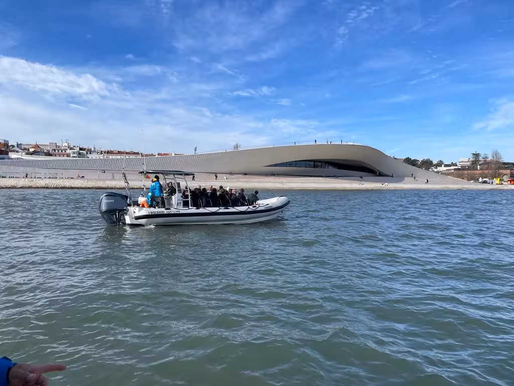 Lisbon sunset speedboat tour cruising past MAAT museum on the Tagus River with panoramic waterfront views