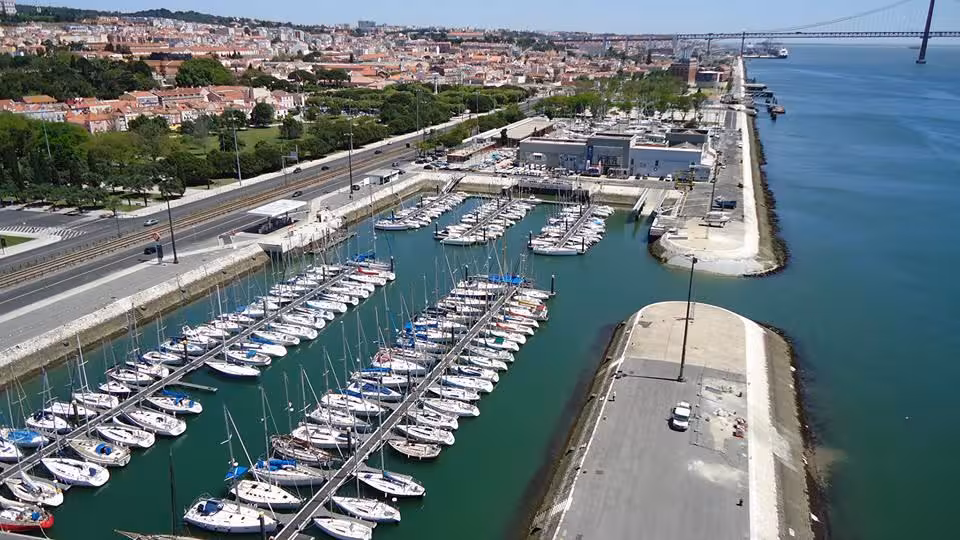 Aerial view of Lisbon marina on the Tagus River near 25 de Abril Bridge, departure for cultural sail tours