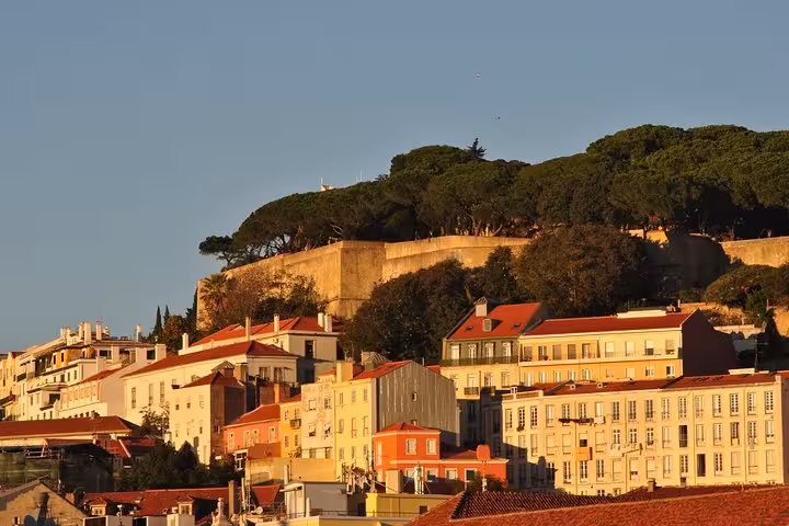 Lisbon old town skyline and São Jorge Castle at sunset, view from Tagus River small group sailing cruise