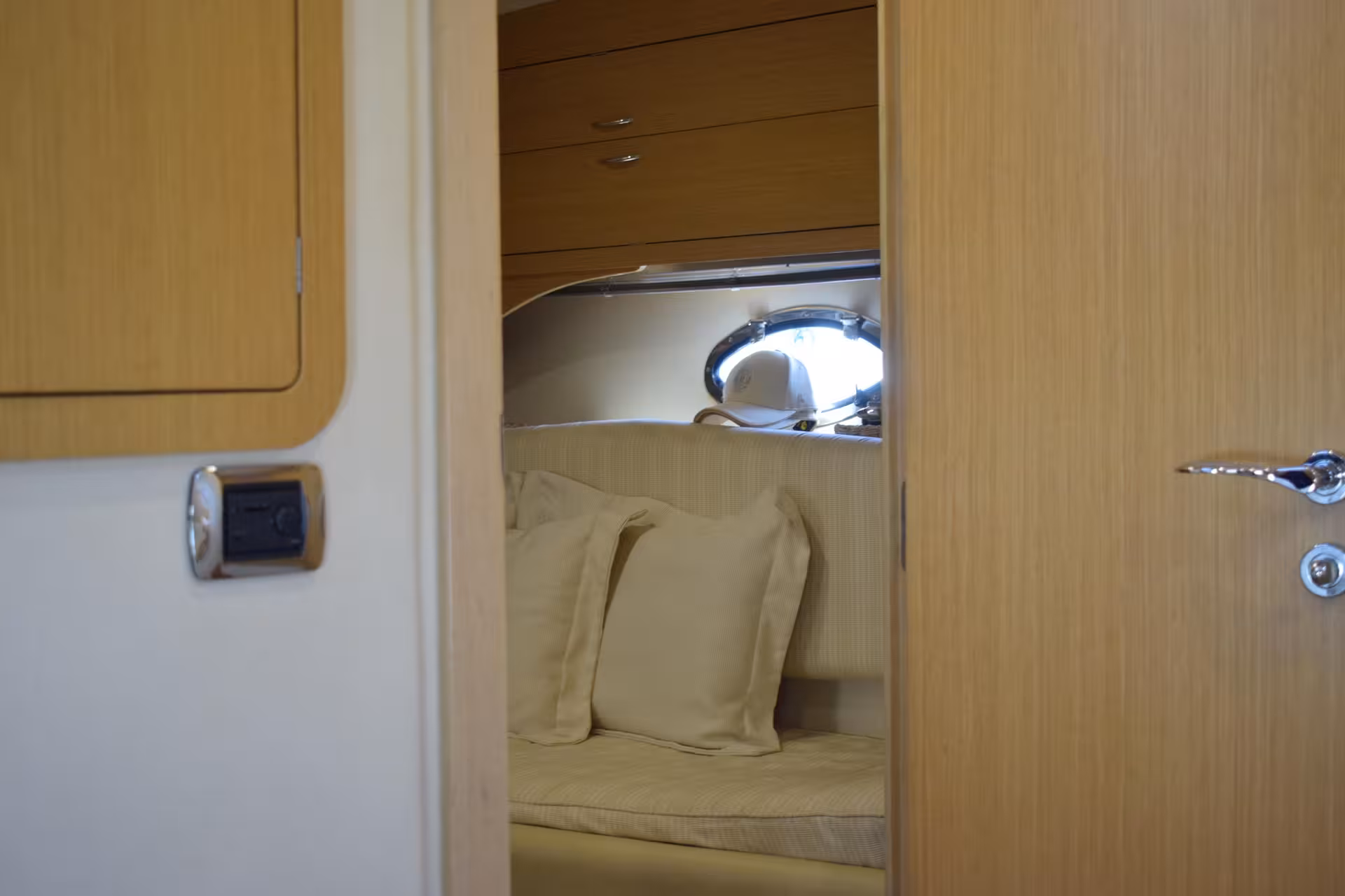 Cozy yacht cabin seating with cushions and porthole, part of A Lisbon Tale by On Tales luxury cruise.