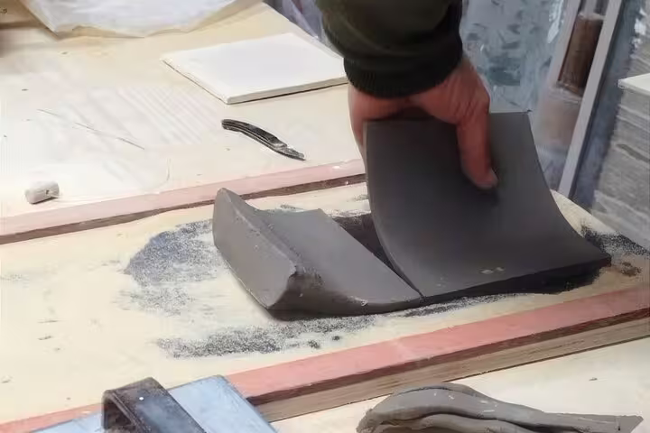 Hands shaping clay at a private tiles painting workshop in Sesimbra, perfect for art lovers and wine tasting enthusiasts.