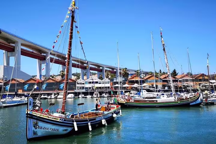 Traditional boats in Lisbon marina under blue sky, perfect for guided sightseeing cruise along the city's scenic waterfront.
