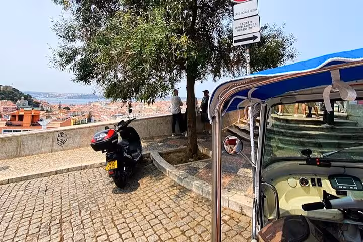 Tuk tuk parked at a Lisbon viewpoint overlooking the city, part of a 3-hour private tour of the historic center