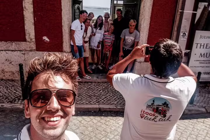Group photo of happy tourists captured during a lively tuk tuk tour in Lisbon, showcasing local sights and smiles.