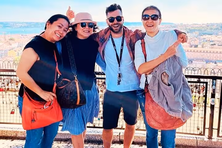 Happy guests at Lisbon viewpoint during 1-hour Old Town tuk tuk tour with panoramic city and river views