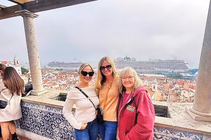 Travelers at Miradouro viewpoint over Alfama and Tagus River on a 2-hour private historic Lisbon tuk tuk tour