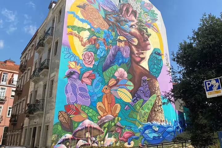 Vibrant Lisbon mural featuring colorful birds and nature, showcasing urban art on the Private Urban Art Tour in Lisbon.