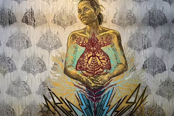 Vibrant mural in Lisbon depicting a serene woman with intricate chest design and botanical elements.