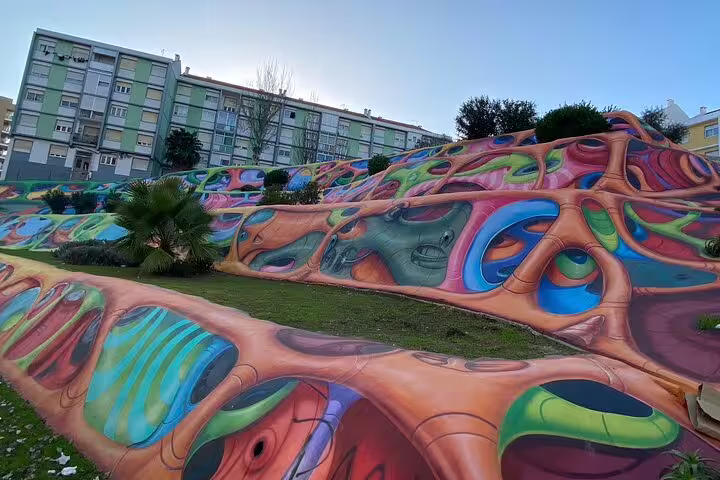 Vivid street art on Lisbon hillside with abstract patterns and colorful designs, highlighting urban creativity.