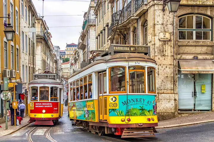 Charming vintage trams navigating the historic streets of Lisbon, a must-see during a private transfer to Porto.