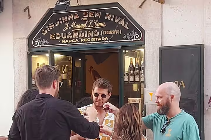 Friends enjoying Lisbon's famous ginjinha at a local bar, highlighting a cultural stop on the walking tour.