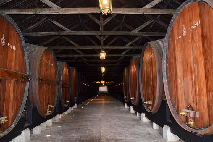 A picturesque wine cellar in Lisbon's South, featuring large wooden barrels, part of a private tour highlighting sights and wine.