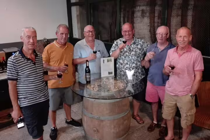 Group enjoying wine tasting at a rustic winery in Arrabida, Portugal, part of a scenic Lisbon sightseeing tour.