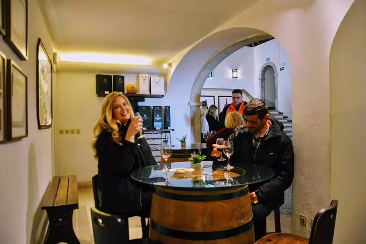 Couple enjoying wine tasting at a rustic cellar in Lisbon's south, highlighting the charm of Portugal's private wine tours.