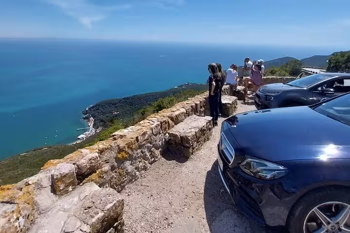 Luxury transport stop at Arrábida coast viewpoint during Lisbon wine tour, scenic ocean views and guests