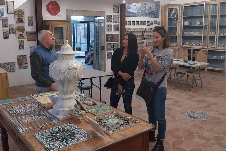 Guests visit a Lisbon azulejo tile studio, cultural stop on an all-inclusive wine and food tasting tour