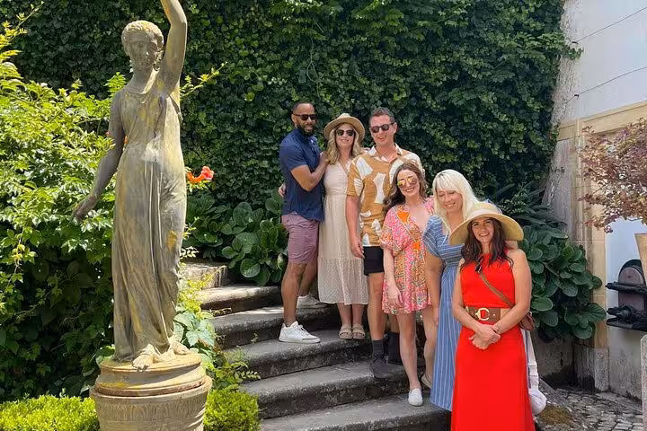 Small group in a leafy Lisbon courtyard, ideal stop on all-inclusive premium wine and food tour