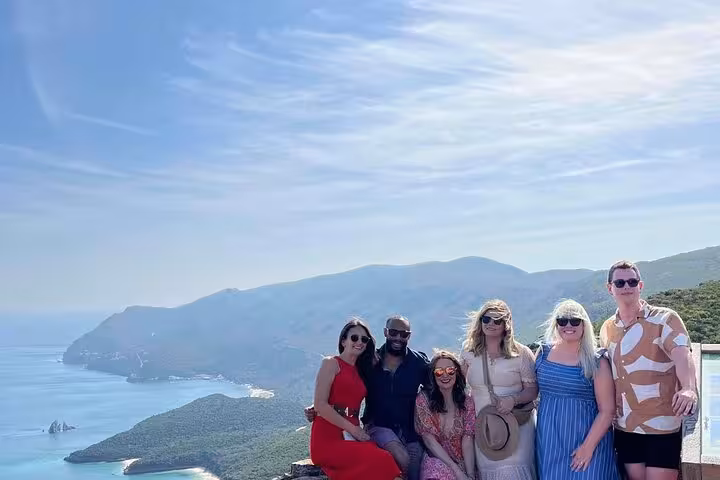 Group photo at a Lisbon wine tour coastal viewpoint, ideal for premium tastings and all-inclusive wine & food