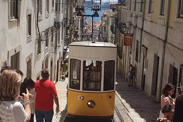 Lisbon yellow Elevador da Bica tram on steep street, ideal for self guided GPS audio walking tour