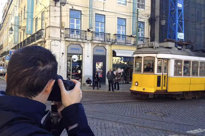 Photographer captures iconic yellow tram in Lisbon city center, perfect for private guided tour exploring historic streets.