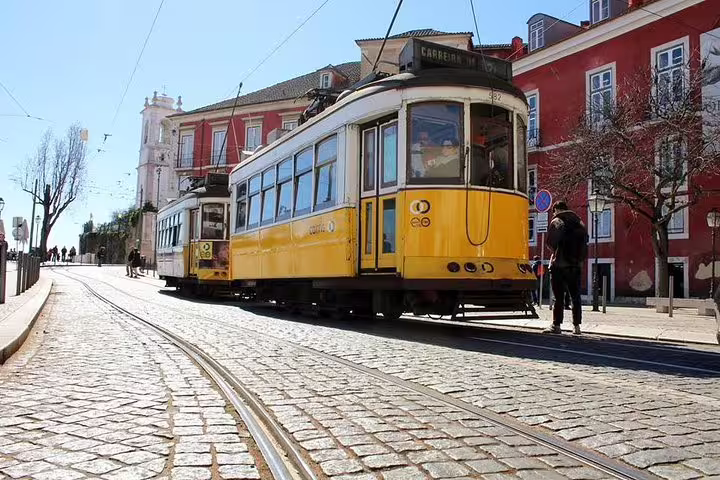 Iconic yellow tram on cobblestone streets in Lisbon, perfect for a private tour exploring Lisbon and Fatima in a full day.