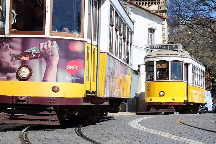 Two iconic yellow trams navigate the charming streets of Lisbon, highlighting a premium private tour experience.