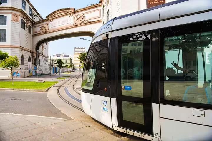 Modern tram passing through historic arches in Rio's Little Africa, showcasing urban exploration on Afro-Brazilian tours.
