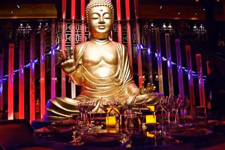 Golden Buddha statue and candlelit tables at Little Buddha Hurghada night out with entrance and transfer