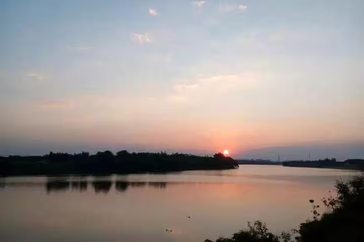 Serene sunset over the tranquil river in Liuxihe National Forest Park, perfect for a private day tour from Guangzhou.