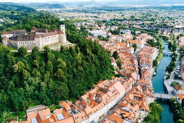 Aerial view of Ljubljana Castle and old town rooftops, highlight of Vienna to Ljubljana private tour