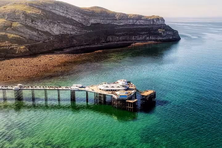 Llandudno Pier over turquoise sea with Great Orme cliffs, coastal view on Snowdonia & 3 Castles Tour