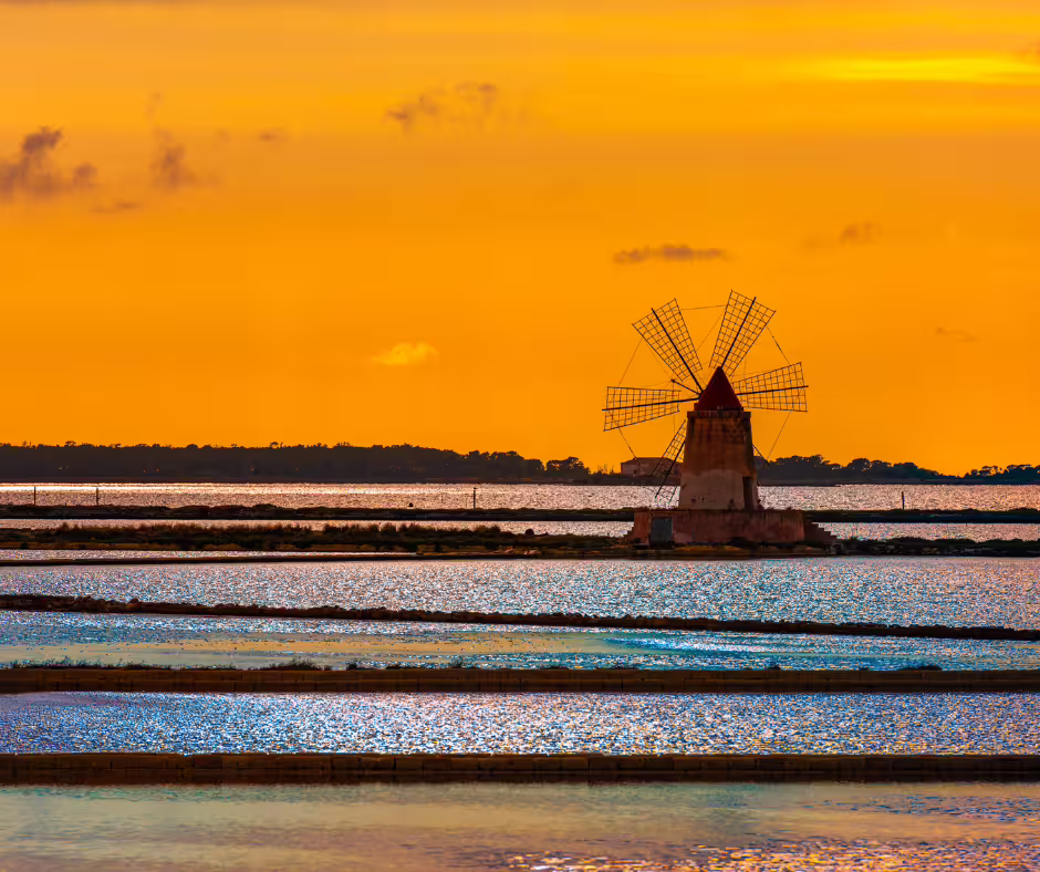 Sunset over Lo Stagnone saltpans with traditional windmill near Mothia Island on Segesta and Erice private tour from Palermo