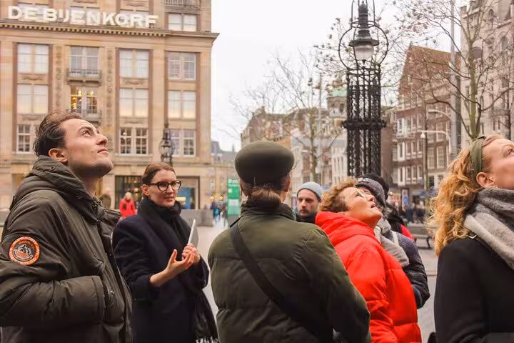 Small group listening to a local guide in Amsterdam city center, private walking experience and hidden gems