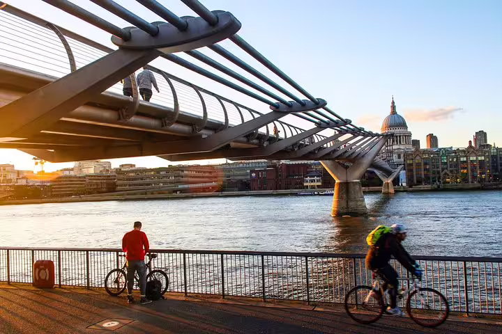 Cyclists enjoy a scenic ride along the Thames with views of St. Paul's Cathedral and Millennium Bridge during a London bike tour.