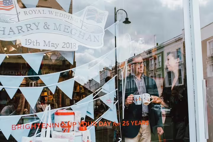 Tourists enjoy London shopfront reflecting Royal Wedding souvenirs on personal travel photographer tour.