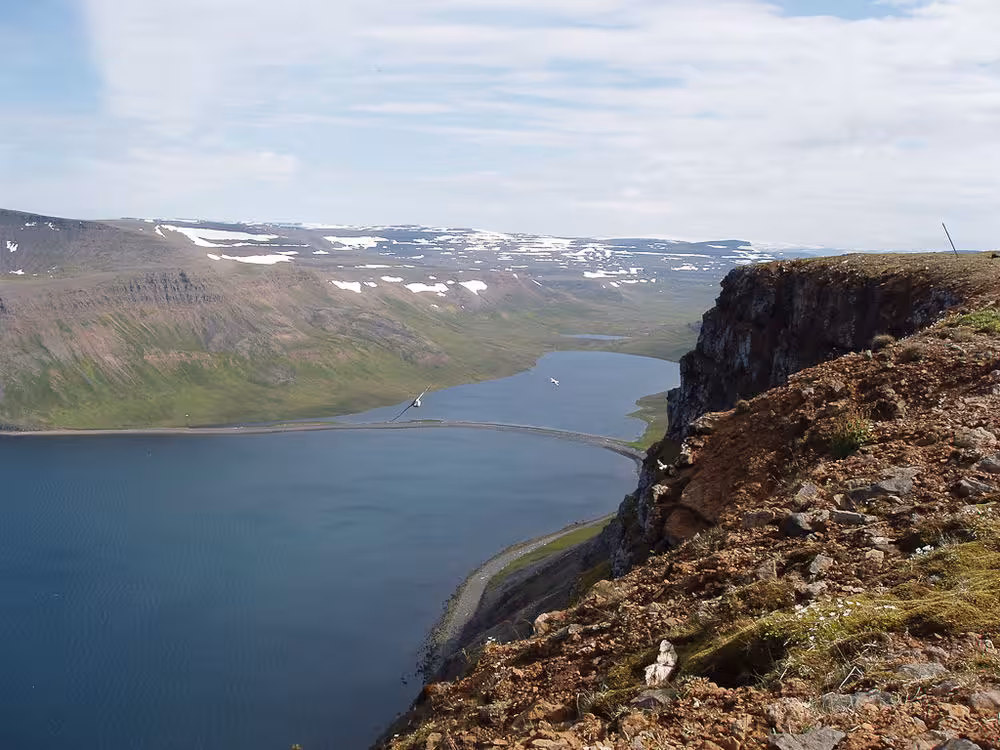Panoramic view over a deep fjord from a cliff edge on the Lost Fjords Westfjords hike, Iceland wilderness scenery
