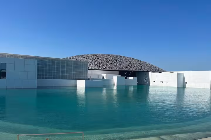 Louvre Abu Dhabi dome over turquoise lagoon, top stop on Abu Dhabi city tour and cultural sightseeing